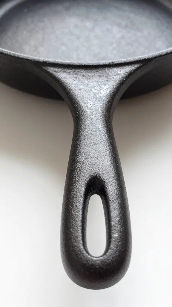 How to Clean Pots and Pans to Look Like New: Easy Fixes 4 closeup cast iron pan handle grip and seasoning shine