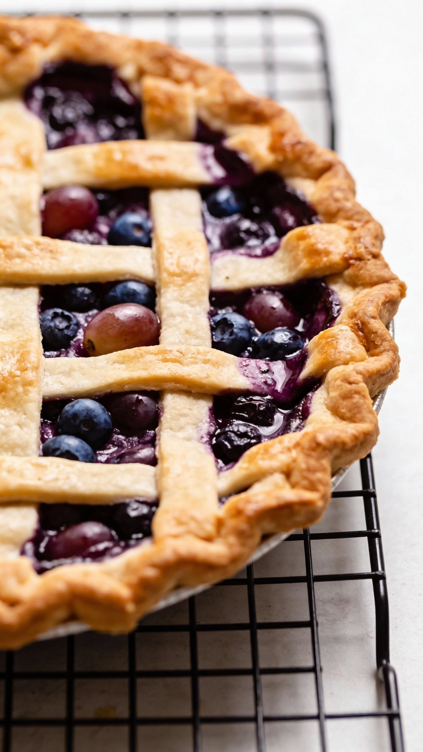 Easy Grape and Blueberry Pie That Tastes Like Summer 5 lattice-topped grape-blueberry pie on cooling rack closeup