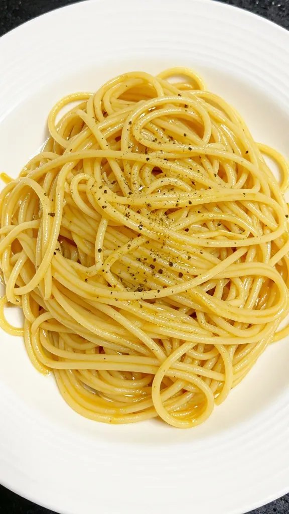 Beginner-Friendly Pasta Aglio E Olio: Quick Wow Pasta 5 Tight shot of perfectly plated spaghetti with buttered-garlic oil glaze on white plate