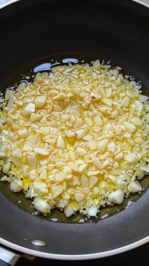 Easy Homemade Marinara Sauce: Quick Weeknight Triumph 4 closeup of minced garlic sizzling in olive oil in a small pan